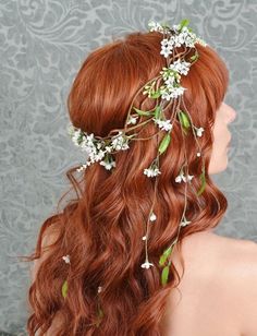 a woman with long red hair and flowers in her hair