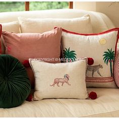 the pillows on the couch are decorated with animals and pom - pompoms