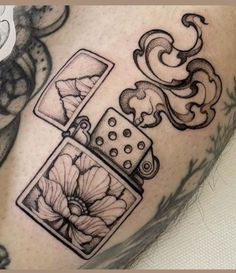 a tattoo on the leg of a man that has some pictures and flowers on it