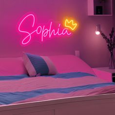 a bed in a room with a neon sign above it that says sophiia