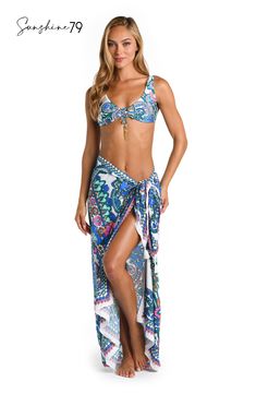 This pareo by Sunshine 79 features an elegant white and blue multicolored paisley print, exuding a blend of sophistication and playfulness. Its intricate pattern adds a touch of bohemian charm to your poolside style. This gorgeous pareo looks equally beautiful with a one-piece suit as it does a bikini top and bottoms. The sarong-style fit that ties at the side lends a chic silhouette. [split] Details Pareo cover up Adjustable side tie with tassels One size fits all Fabric 100% Rayon Crepe White Floral Print Swimwear For Beach Cover-up, Bohemian Tropical Print Sarong For Pool, Bohemian Sarong With Tropical Print For Pool, Bohemian Blue Printed Swimwear, White Printed Cover-up For Pool, Bohemian Blue Swimwear With Floral Print, Bohemian Printed Pool Cover-up, Bohemian Vibrant Print Sarong For Vacation, Bohemian Blue Floral Print Swimwear