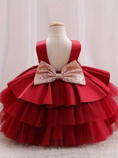 Make your little one the belle of the ball with this classic red princess gown. The dress boasts a sleek, sleeveless top and a plush, multi-layered tulle skirt that's made for twirling. A shimmering gold bow adorns the waist, providing a beautiful contrast to the deep red. It's an ideal choice for flower girls, birthday parties, or any event where making a statement is a must. Size Chart Size Chart US Shoulder (inches) Bust size (inches) Waist size (inches) Length (inches) 6-9M 7.9 20.5 19.7 17. Elegant Christmas Princess Dress In Tulle, Elegant Tulle Ball Gown For Christmas, Elegant Christmas Tulle Princess Dress, Elegant Christmas Tulle Ball Gown, Princess Tulle Holiday Dress For Christmas, Princess Style Tulle Holiday Dress For Christmas, Elegant Christmas Tutu Dress In Tulle, Elegant Christmas Tulle Tutu Dress, Holiday Sleeveless Princess Dress With Ruffles