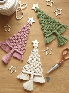 crocheted christmas tree ornaments with scissors and yarn on the table next to them