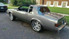 a silver sports car parked in front of a brick building