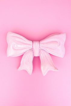 a white bow on a pink background