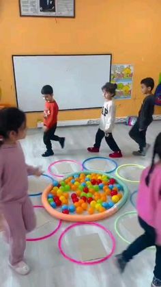 children are playing with an inflatable ball pit while others watch from the floor