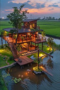 an aerial view of a house on stilts in the middle of water at dusk