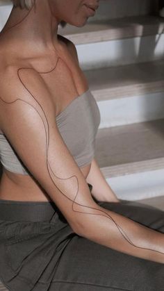 a woman is sitting on the stairs with her arm painted like a heart and lines