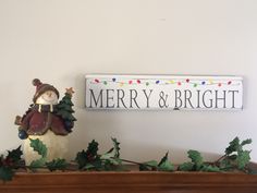 a merry and bright sign on top of a mantle