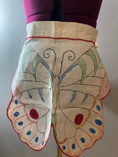 a close up of a dress on a mannequin's torso with an embroidered butterfly design