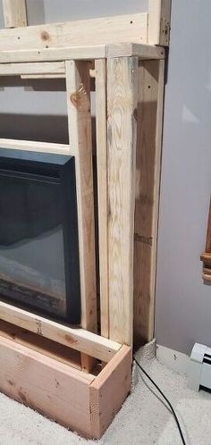 an old tv sitting in a wooden box on the floor next to a wall mounted television