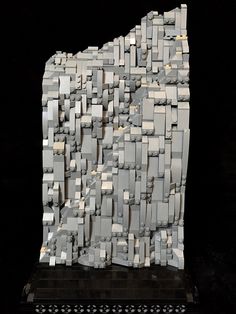 a sculpture made out of several blocks of gray and white material on a black surface