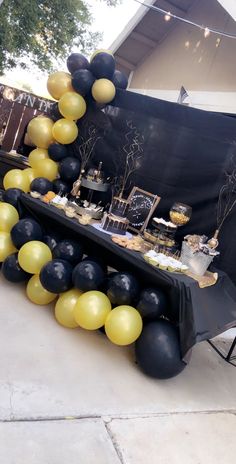 a table topped with black and yellow balloons