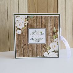 a card with white flowers and greenery on it