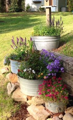 three flower pots sitting on top of a pile of rocks