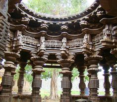 an intricately carved wooden structure in the middle of a park