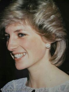 an old photo of a woman smiling for the camera with her hair in a bun