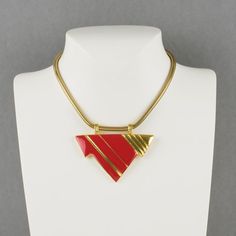 Lovely Lanvin Paris modernist pendant choker necklace. Serpentine gilt metal chain ornates with geometric pendant in shiny gilt metal and red enamel. Spring ring-closing clasp. Signed with a little gilded tag underside the pendant: "Lanvin - Paris." Measurements: total length 15.38 in (39 cm) - pendant: 2.88 in wide x 2.38 in high (7.3 x 6 cm).  Please see the measurements noted above, in the description for the best approximate dimensions. Modern Gold Collectible Jewelry, Modern Gold Jewelry For Collectors, Retro Red Metal Jewelry, Red Retro Metal Jewelry, Formal Red Enamel Necklaces, Formal Red Enamel Necklace, Red Enamel Jewelry With Large Pendant, Red Metal Necklace With Large Pendant, Modern Gold Enamel Jewelry