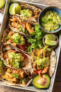 a tray filled with tacos and guacamole