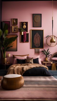 a bedroom with pink walls and pictures hanging on the wall, including an ottoman bed