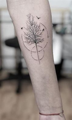 a person's leg with a tree tattoo on the left side of their arm