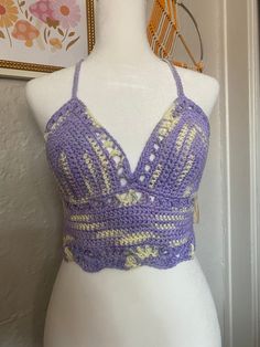 a white mannequin wearing a purple crochet bralet with yellow stripes