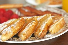 several pastries are on a plate with berries and orange juice in the back ground