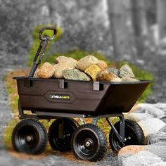 a wheelbarrow filled with rocks on the ground next to some trees and rocks