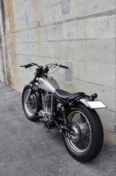 a motorcycle parked next to a concrete wall