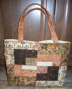 "Looking for a great gift or treat yourself to this quilted tote bag / purse.  Lovely batik fabric in shades of copper, bronze, cream and brown.   Convenient size of 16\" wide x 12\" tall x 3\" wide base. Button closure at the top,  along with four pockets inside.  Perfect for cell phone, pens, personal items.  Machine washable in cool water.  Hang to dry. If you are looking for a custom bag in your choice of colors, contact me today! Made in a pet-free and smoke free studio." Quilted Tote Bags, Quilted Totes, Tote Bag Purse, Batik Fabric, Custom Bags, Zipper Bags, Inside Pocket, Batik, Ted Baker Icon Bag