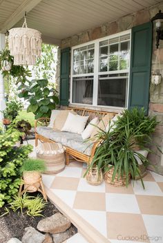 the porch is decorated with plants and wicker furniture