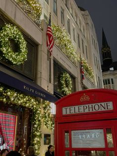 a red phone booth with christmas lights on it