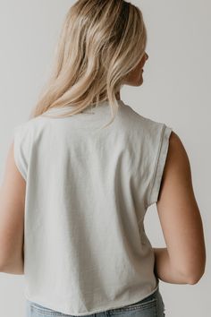 a woman with blonde hair wearing a white shirt and jeans, looking off to the side