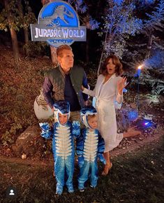 a family poses for a photo in front of the jumbo world sign at night