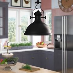 a kitchen with an island and large pendant light hanging from it's center beam