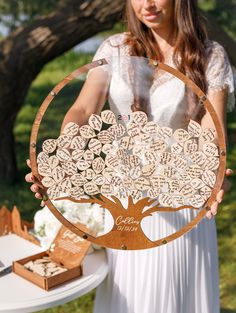 a woman holding up a wooden family tree