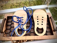 two pairs of shoes with blue laces sit in a box on the ground outside