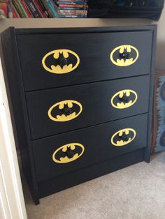 a black dresser with yellow batman decals on it