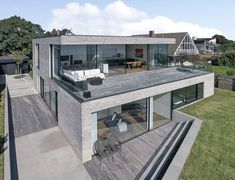 an aerial view of a modern house with large windows and decking on the ground