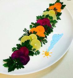 a white plate topped with cut up fruit and veggies on top of it