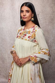 Off white kalidar kurta with floral embroidered yoke and sequin detailing. Paired with dhoti and scallop hem dupatta.
Component: 3
Printed, Embroidered
Neckline: Round
Sleeve Length: Three Quarter
Fabric: Mulmul, Kota Doria
Color: White
Drawstring with tassels at the side
Front potli placket
Pearl detailing at the sleeves
Printed detailing on the dhoti
Tassels on the dupatta
Note: Potli shown in the image is not for sale - Aza Fashions Designer White Churidar With Floral Embroidery, White Churidar With Floral Embroidery For Designer Wear, White Churidar With Floral Embroidery For Designer Occasions, Anarkali Set With Floral Embroidery In Maxi Length, White Floral Embroidered Churidar For Designer Wear, Anarkali-style Fitted Sharara With Floral Embroidery, Diwali Sharara With Floral Embroidery And Straight Kurta, Anarkali Style Fitted Sharara With Floral Embroidery, Festive Maxi Salwar Kameez With Floral Embroidery