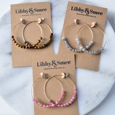 Think of these semi precious beaded hoop earrings as Libby & Smee Deluxe! Quite simply, these'll be the hoops that you'll want to wear every single day. Plus the gemstones all offer a little woo-woo — if that's your thing! 45mm (about 1.75") gold-filled hoops with gemstone beads packaged on a kraft earring card in a clear resealing bag gold-filled hoops are lead-free gold over brass. Gold-filled has much more gold than gold-plated and will last longer without tarnishing. TIGER EYE is said to Round Gemstone Beads Hoop Earrings As Gift, Gift Small Hoop Beaded Earrings Wire Wrapped, Gift Gemstone Beads Hoop Earrings, Beaded Brass Hoop Earrings For Gift, Multicolor Wire Wrapped Small Hoop Beaded Earrings, Diy Earring Cards, Hoop Earrings Diy, Woo Woo, Gemstone Hoop Earrings