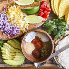 mexican food is laid out on a table with tortillas, limes and peppers