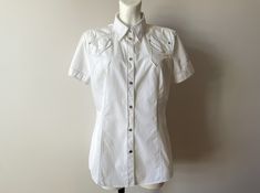 Vintage White summer cotton top, short sleeve women's blouse, denim style shirt, bohemian snap button up top, summer days shirt Label size: UK 16 / US 12 /  Measurements: Shoulders: 16.5 in Pit to pit: 21 in Length: 28 in Sleeve: 7.5 in Material: cotton Please check measurements to insure a proper fit. Remember to allow yourself some extra room for movement. You can compare these with something from your closet that fits you well. Please convo me if you need additional measurements. This blouse Summer Cotton Button-up Blouse, Fitted Summer Shirt With Button Closure, Fitted Short Sleeve Shirt With Buttons For Summer, Cotton Summer Blouse With Buttons, Trendy Button-up Short Sleeve Shirt For Summer, Fitted Short Sleeve Shirt With Pockets For Summer, Summer Cotton Short Sleeve Shirt With Button Closure, Summer Short Sleeve Tops With Snap Buttons, Bohemian Short Sleeve Shirt