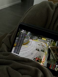 a person is holding a tablet with a video game on the screen in their lap