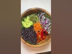 a wooden bowl filled with different types of vegetables