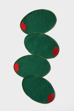 three pieces of green felt with red dots on the bottom and one piece in the middle