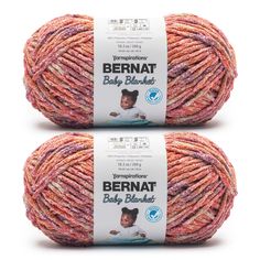 two balls of yarn with the words bernat baby blends on them in pink and orange