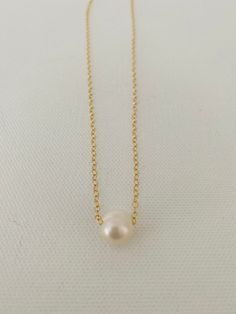 Just A Pearl! This simple yet elegant necklace is part of my Just A Pearl collection. One single pearl dangles from a delicate gold necklace. It measures 16 inches and length and can be adjusted to 15 inches for choker length. Minimalist Pearl Charm Chain Necklace, Simple Pearl Chain Necklace, Minimalist Pearl White Chain Necklace With Pearl Drop, Classic Gold Charm Necklace With Pearl Drop, Minimalist Pearl Drop Chain Necklace In Pearl White, Classic Pearl Necklace With Delicate Chain, Minimalist Pearl White Necklace With Delicate Chain, Minimalist Gold Charm Necklace With Pearl, Minimalist Yellow Gold Pearl Necklace