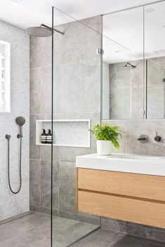 a bathroom with a sink, mirror and shower head in the corner next to it